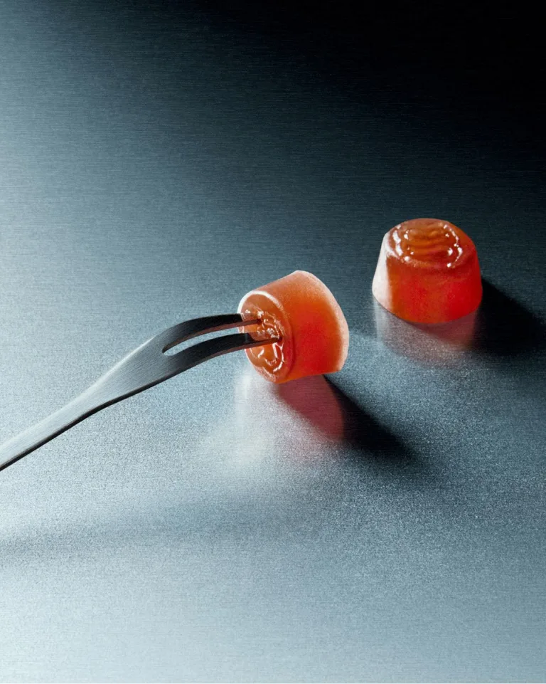 Two Sakara Fiber Bite gummies on a flat silver surface