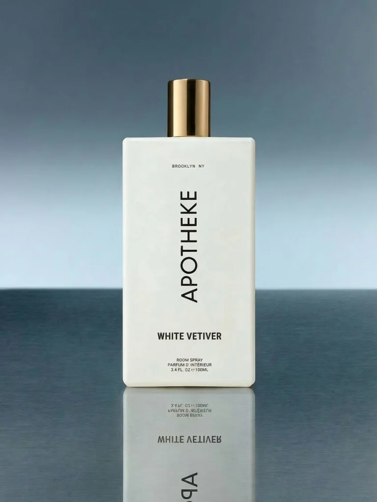 Apotheke White Vetiver Room Spray on a dark blue surface with a light blue background