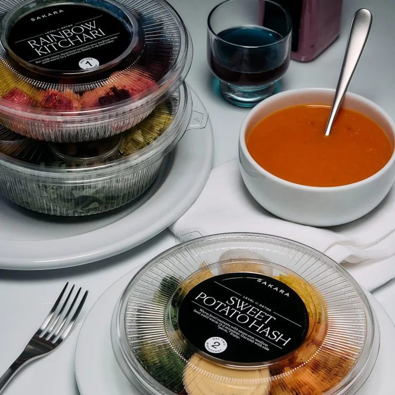 Sakara Level II: Detox meals in plastic packaging alongside a dark red soup in a white bowl