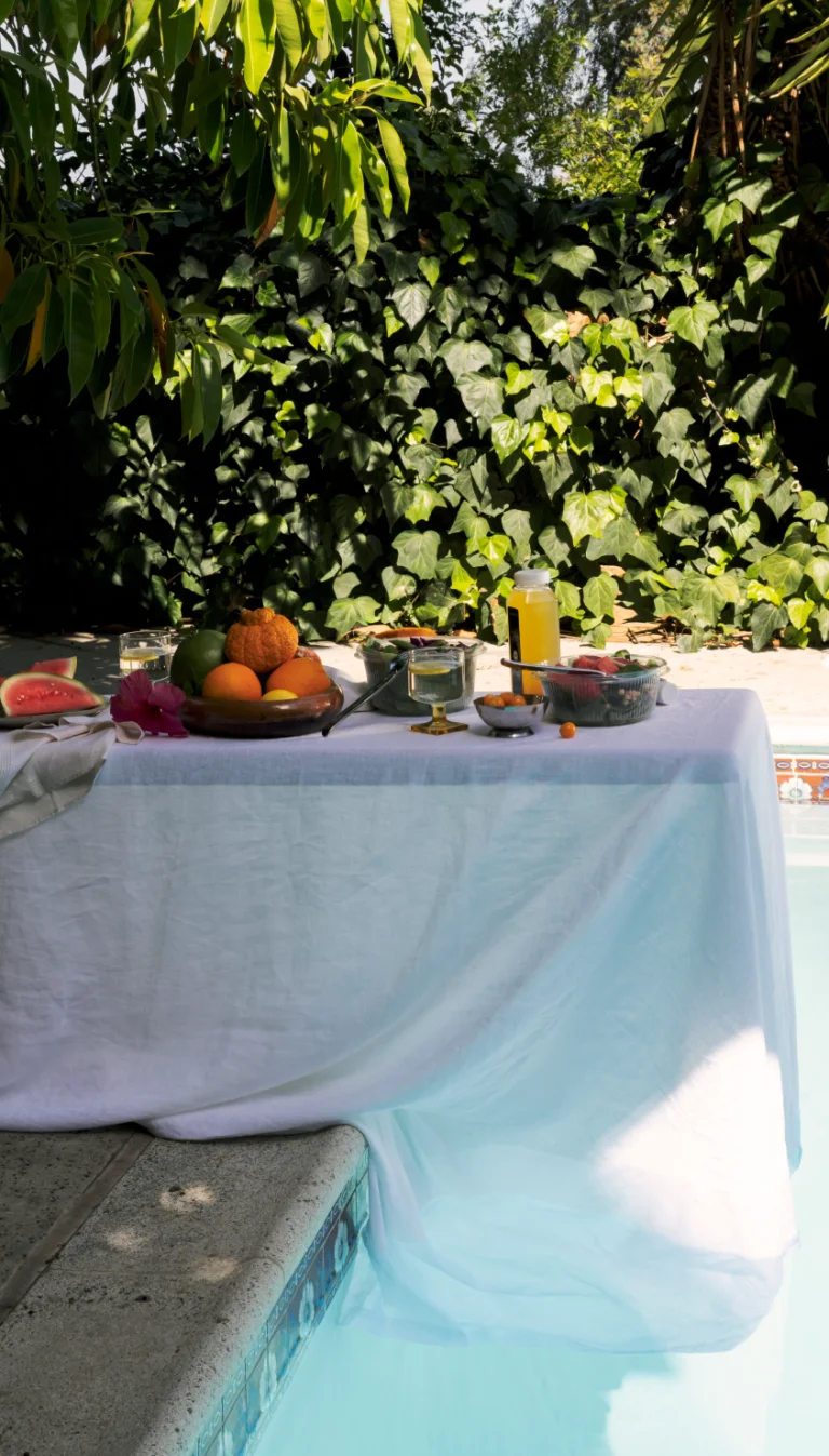Table set with food on diving board covered in white tablecloth