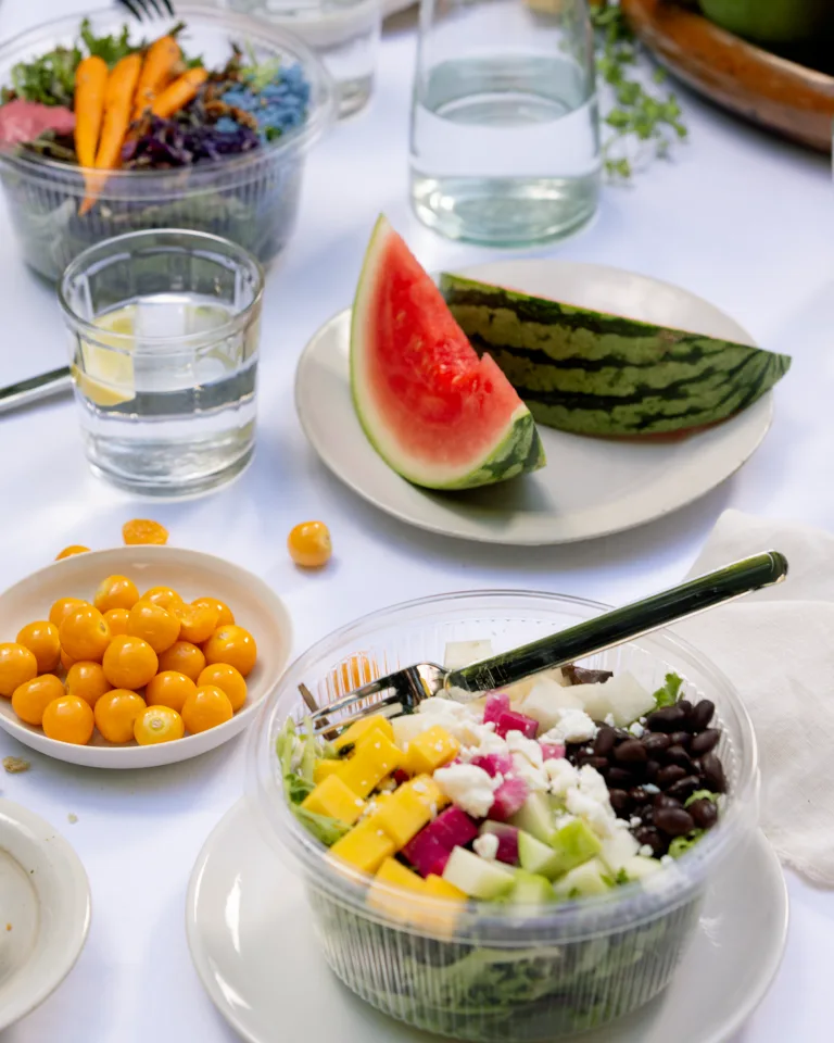 Salad and Watermelon slice on table with white tablecloth