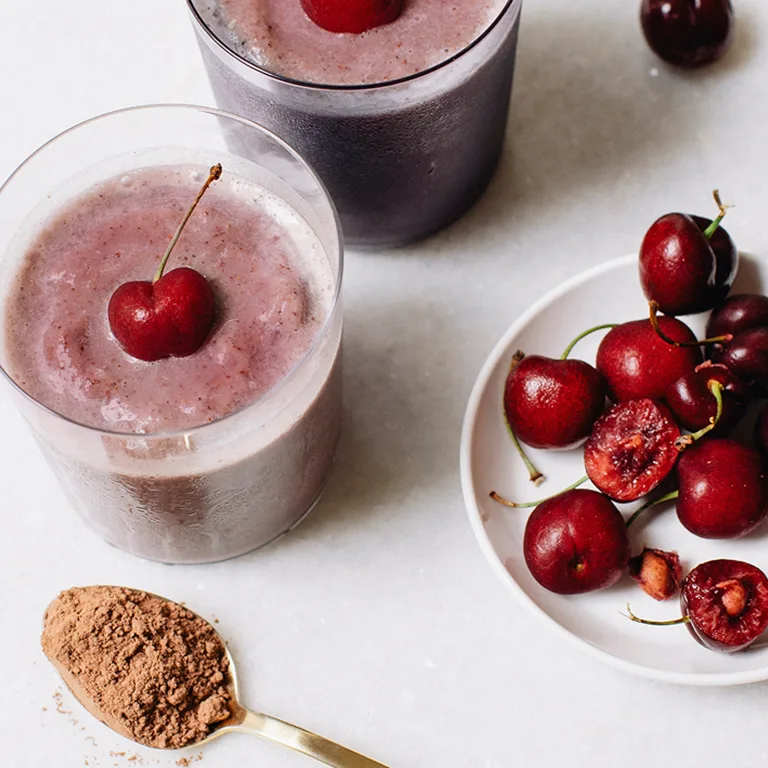 picture of small plate with cherries and a glass cup with MSP mixed in with a cherry on top and spoonful of Metabolism Super Powder on the side